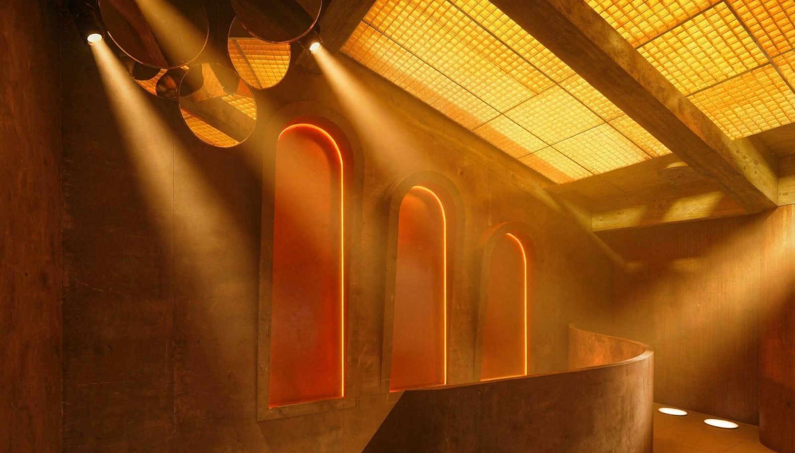 Mombassa, Tarifa: hornacinas en arco con luz naranja y techo luminoso de pavés — Studio Eleven