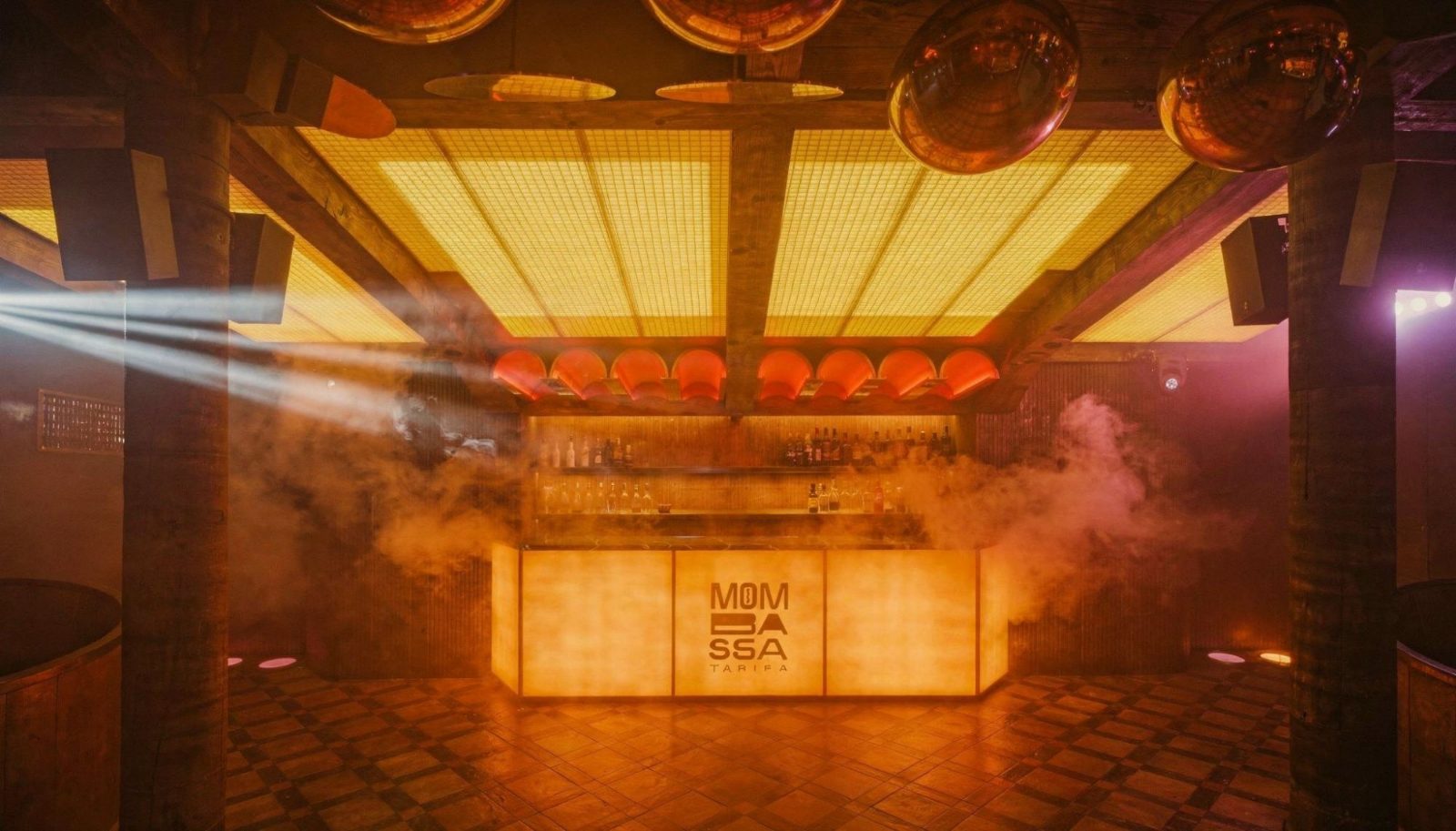 Mombassa, Tarifa: barra retroiluminada bajo techo de pavés ámbar y lámparas de cobre — interiorismo de Studio Eleven
