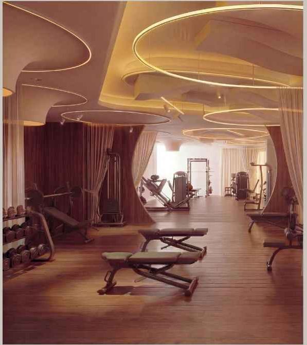 The Qlture Velázquez, Madrid: zona de entrenamiento con bancos y pesas bajo techo luminoso — Studio Eleven